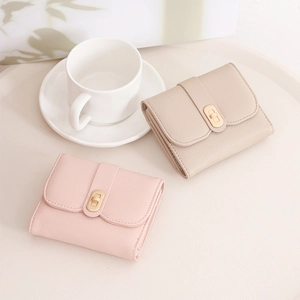 Detail of compact women's wallets with pebble leather texture and gold metal buckles