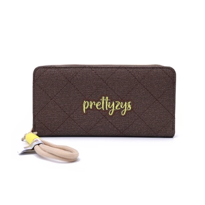 Detail of dark brown quilted wallet with embroidered logo and wristlet strap detail