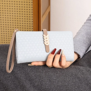 Close-up of light blue leather wallet with gold leaf buckle and wrist strap detail