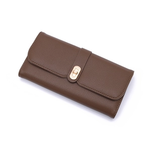 Detailed view of the dark brown pebble leather texture and golden metal twist lock closure