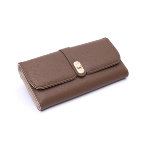 Detail of coffee brown long wallet showing pebble leather texture and gold twist lock