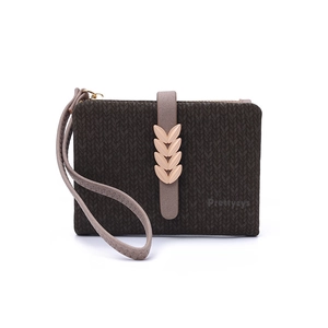 Detail of dark brown wallet with leaf clasp, knitted texture, and wristlet strap
