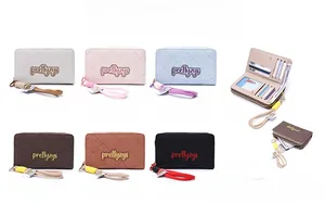 Detail of multi-color PU leather checkered wallets with zippers and hand straps