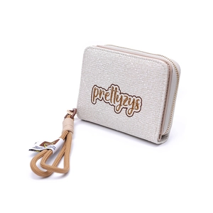 Détail du portefeuille beige matelassé avec broderie et dragonne amovible assortie
