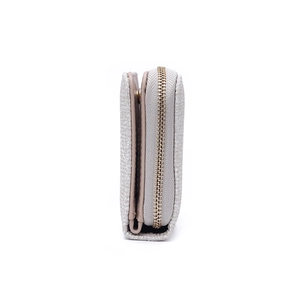 Détail du portefeuille beige clair avec compartiments multiples et finitions dorées brillantes