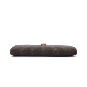 Detail view of coffee brown wallet with V-shaped knit pattern and pink buckle closure