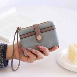 Detail view of misty blue matte PU leather wallet with wristlet and golden hardware