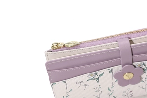 Detail of floral clasp and daisy pattern on purple patchwork long wallet for women