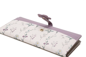 Close-up of floral print long wallet featuring purple petal buckle and leather details