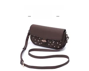 Detail of dark brown leather crossbody bag with golden flower hardware and patterned pockets