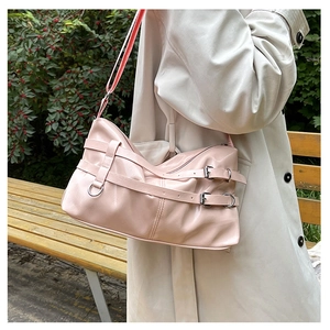 Light pink patent leather tote bag with metallic buckle straps and a minimalist design