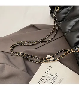 Close-up of black quilted shoulder bag featuring woven leather chain strap and diamond stitching
