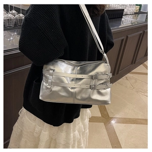 Details einer silbernen Metallic-Schultertasche mit Doppel-Schnallen-Design und Reißverschluss