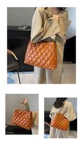 Detailed view of caramel quilted tote bag with metal chain strap worn by a model
