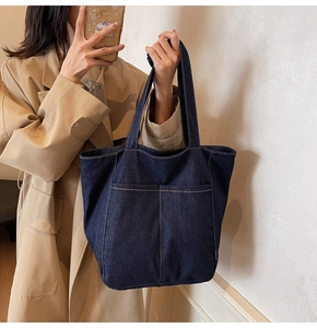 Deep blue denim tote bag with large double front pockets and contrast stitching details