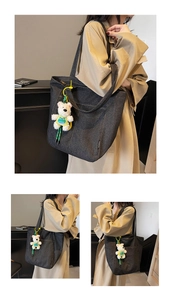 Detail of dark grey denim tote bag with plush bear charm and side fashion label