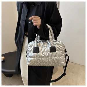 Detail der silbernen Metallic-Stepptasche aus Nylon mit schwarzem Schultergurt