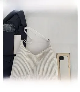 Size comparison showing white corduroy hobo bag next to a tablet and a mobile phone