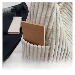 Close-up of white corduroy tote bag side pocket with a notebook inside for detail