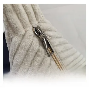 Detailed macro view of high-quality smooth metal zipper on white corduroy shoulder bag