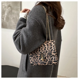 Detail of leopard print chain bag featuring plush fabric texture and gold metal buckle