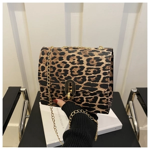 Close-up of leopard print crossbody bag featuring golden chain and metal oval lock buckle