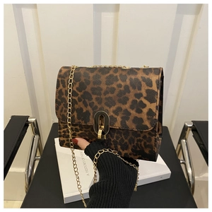 Close-up of leopard print crossbody bag with gold chain strap and metal clasp lock