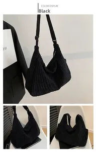 Detailed close-up of black corduroy hobo bag texture and adjustable wide shoulder strap