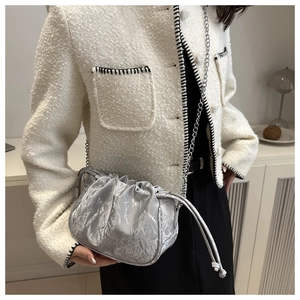 Silver metallic wrinkled cloud bag with chain strap styled with a white tweed jacket