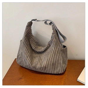 Detailed close-up of grey corduroy shoulder bag showing vertical ribbed fabric texture
