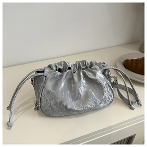 Detail of silver metallic cloud bag featuring ruched texture and elegant chain strap