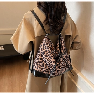 Close-up of leopard print backpack with bow detailing on a trench coat model