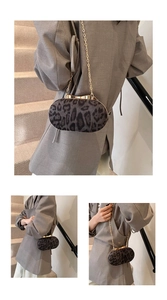 Detail van luipaardprint tas met gouden striksluiting en elegante metalen kettingriem