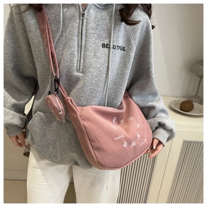 Pink corduroy crescent hobo bag with matching mini round pouch shown on model