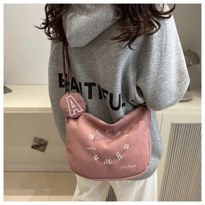 Retro pink corduroy crossbody bag with small round coin purse shown on a model