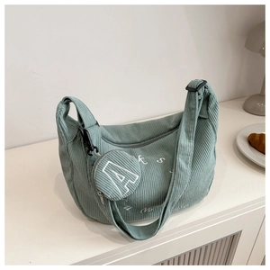 Detailed texture of light green corduroy hobo bag with letter embroidery and round pouch