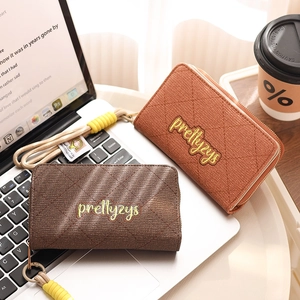 Detail of dark brown and brick orange quilted PU leather wallets with wristlet straps