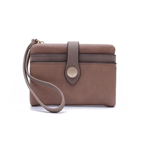 Close-up of vintage bifold wallet showing the textured brown PU leather and metal snap button