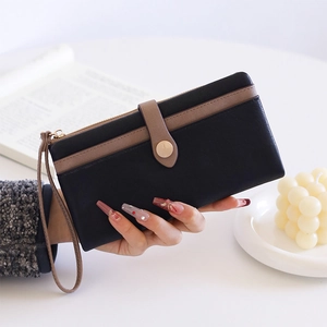 Détail du portefeuille long en cuir PU noir avec bordure marron et fermeture éclair dorée