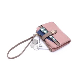 Detail of pink faux leather wallet showing zipper pocket and card slots with hand strap