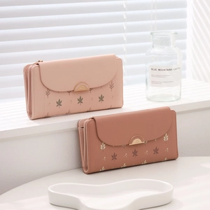 Close-up of trifold wallet metal clasp with delicate leaf print on soft PU leather