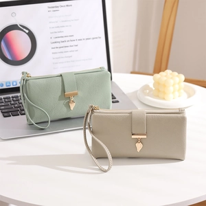 Detalle de carteras largas de cuero PU verde menta y beige con colgantes