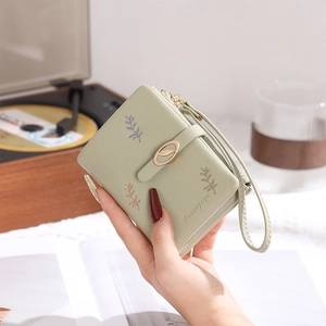 Detailed view of light green PU leather wallet featuring leaf embroidery and metal buckle