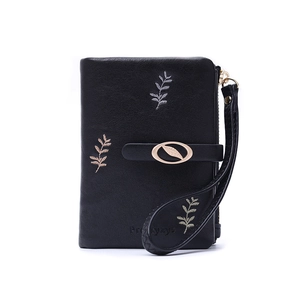 Detail of black leather wallet with leaf embroidery and metal buckle closure