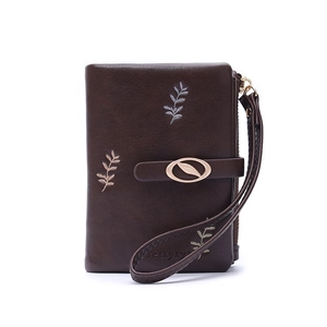 Detail of dark brown leather wallet with three embroidered leaves and metal leaf clasp