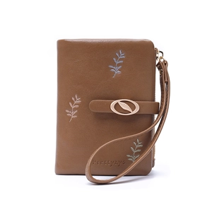 Detailed view of caramel PU leather wallet with leaf embroidery and metal leaf clasp strap