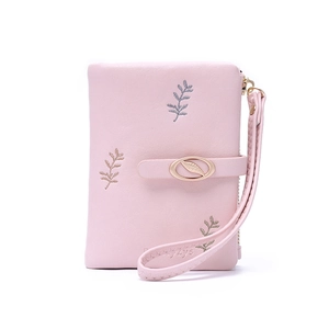 Detail of pink PU leather wallet featuring gold leaf embroidery and metal leaf clasp