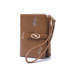 Detail view of brown PU leather wallet featuring embroidery leaves and gold leaf buckle