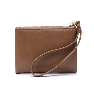 Detailed macro of brown leather wallet texture with gold zipper and round wrist strap