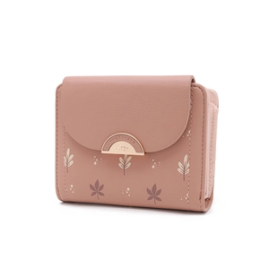 Détail du portefeuille en cuir rose avec imprimé feuilles et boucle dorée